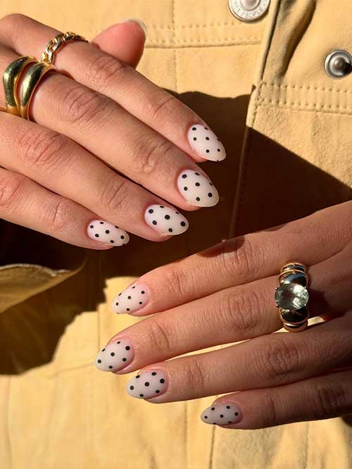 Elegant almond-shaped polka dot nails with a clear finish and tiny black polka dots, offering a chic and minimalist style. Elegant almond-shaped polka dot nails with a clear finish and tiny black polka dots, offering a chic and minimalist style.