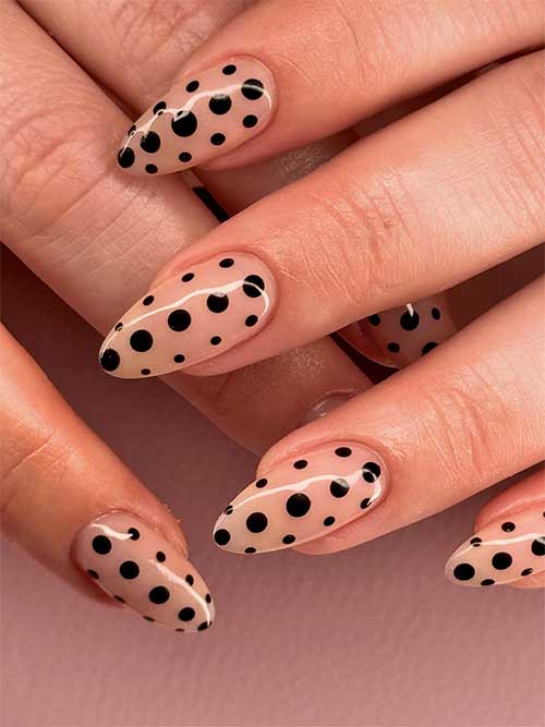 Elegant nude base nails adorned with black polka dots, versatile for both casual and professional occasions. Elegant nude base nails adorned with black polka dots, versatile for both casual and professional occasions.