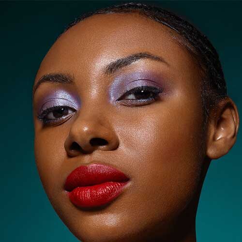 Elegant purple eyeshadow in lilac and violet tones, and red lips, is one of the perfect purple eyeshadow looks.