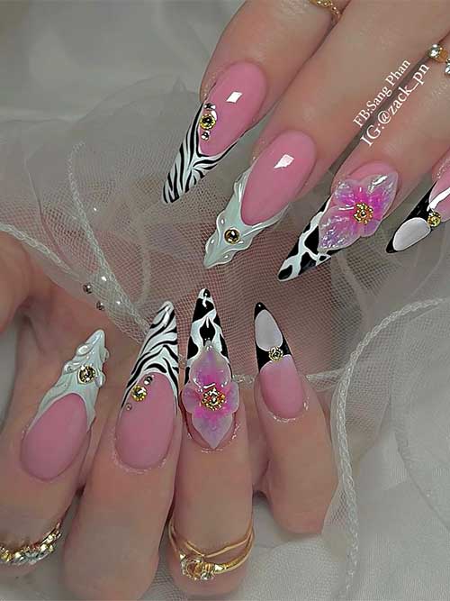 Eye-catching nail design with cow and zebra prints, classic French tips, pink base, 3D floral accents, and gold studs.