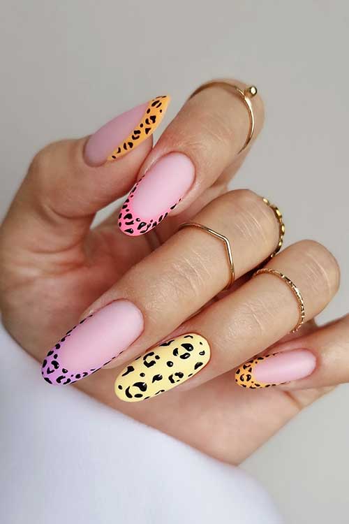 Fierce animal print French manicure on almond nails, blending pastel pink and yellow with vibrant tips in orange, pink, and purple.