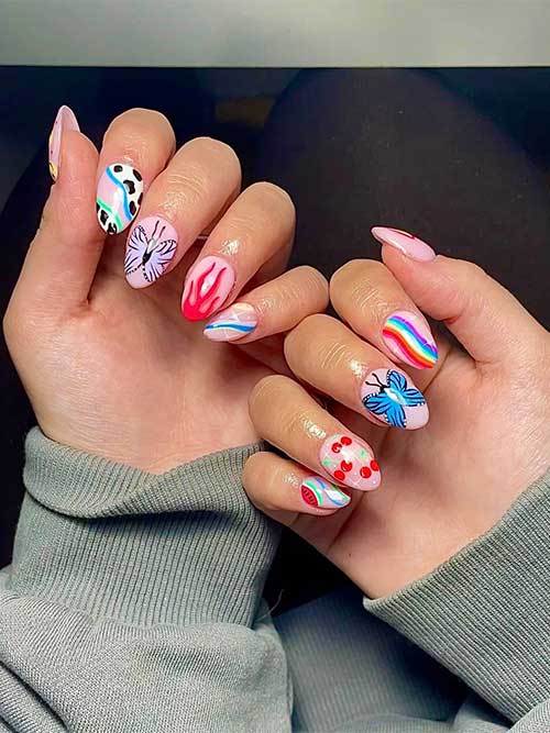 Funky almond-shaped nails with playful designs including cow print, butterflies, and flames, all on a light pink background.