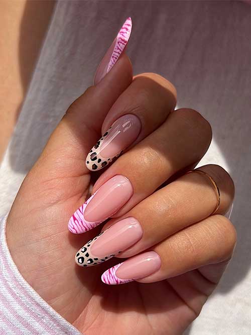 Light pink and bold black animal print French manicure with almond-shaped nails featuring leopard and zebra tips.