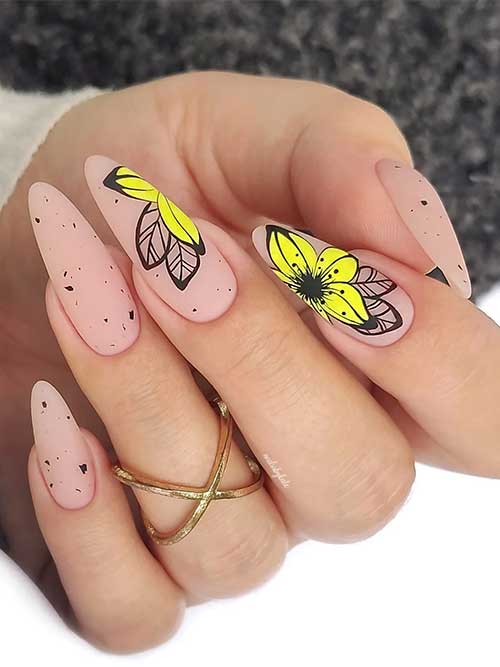 Modern matte nude almond nails with playful black speckles and vibrant yellow flowers for a stylish, artistic look. Modern matte nude almond nails with playful black speckles and vibrant yellow flowers for a stylish, artistic look.