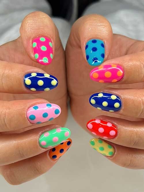 Multi-colored polka dot nails eaturing pink, green, yellow, and blue on a clean background with a glossy finish. Multi-colored polka dot nails eaturing pink, green, yellow, and blue on a clean background with a glossy finish.