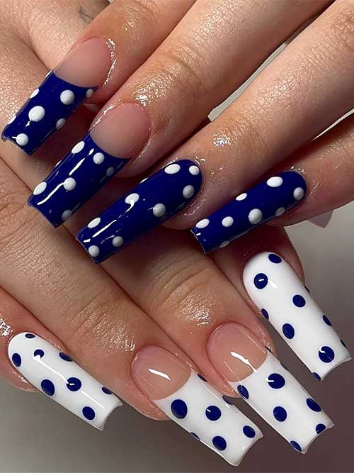 Navy polka dot nails with white dots on one hand, and white dots on navy on the other, showcasing a polished, fun design. Navy polka dot nails with white dots on one hand, and white dots on navy on the other, showcasing a polished, fun design.