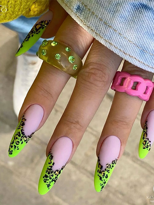 Neon green leopard print French tips on a matte pink base create a bold, eye-catching summer manicure in an almond shape.
