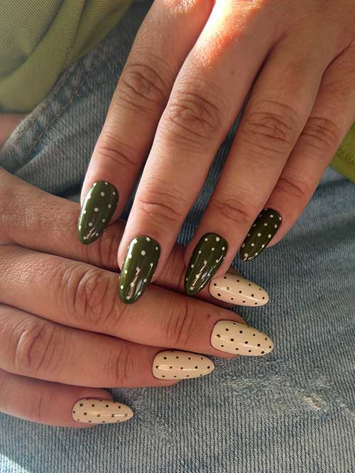 Olive green nails with white dots complement cream nails with black dots, creating a unique, nature-inspired almond shape. Olive green nails with white dots complement cream nails with black dots, creating a unique, nature-inspired almond shape.