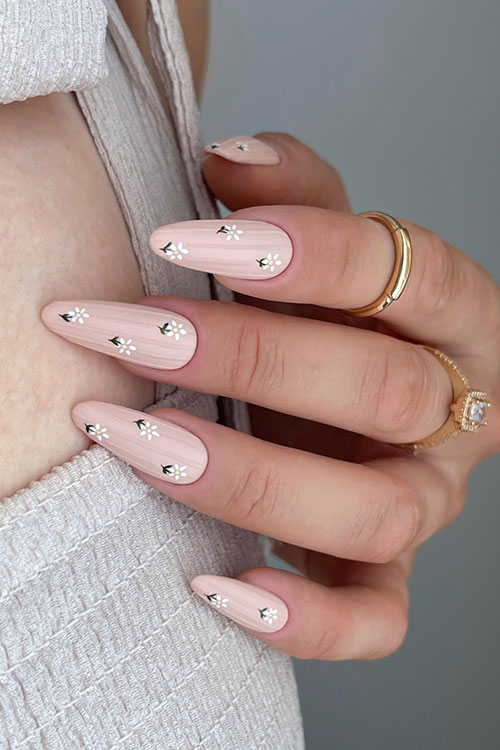Romantic nude almond nails with intricate white flowers, blending elegance and whimsy for special occasions or everyday grace. Romantic nude almond nails with intricate white flowers, blending elegance and whimsy for special occasions or everyday grace.