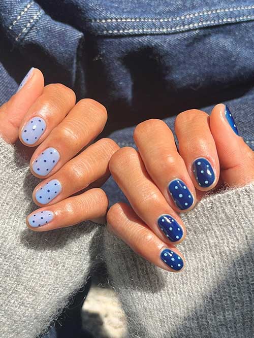 Stylish two-toned polka dot nails: light blue base with dark dots on one hand, dark blue with white dots on the other. Stylish two-toned polka dot nails: light blue base with dark dots on one hand, dark blue with white dots on the other.
