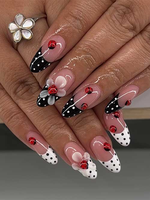 Whimsical almond nails featuring black and white polka dots, red ladybug accents, and 3D floral designs for a stylish touch. Whimsical almond nails featuring black and white polka dots, red ladybug accents, and 3D floral designs for a stylish touch.