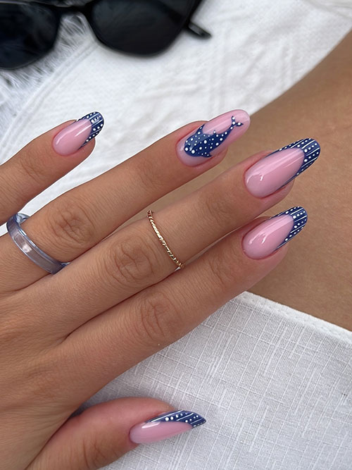French summer nails with almond shape, blush-pink base, navy tips, playful polka dots, and a cute whale on one nail.