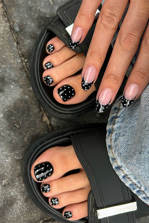 Polka dot manicure and pedicure set featuring nude nails, black tips, and white dots for a playful, chic look.