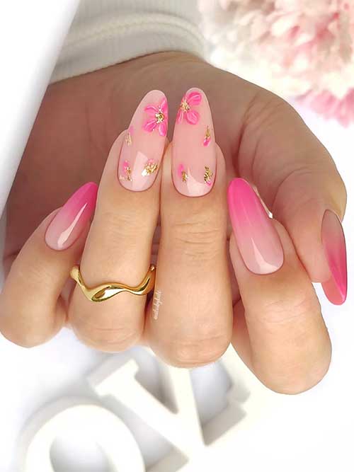 Stunning pink ombre nails featuring delicate floral designs and gold leaf accents, embodying spring's charm and elegance.