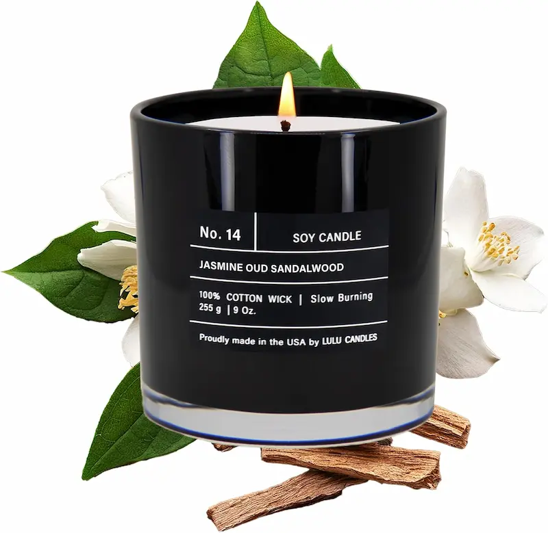 Lulu Candles black glass jar with jasmine oud and sandalwood soy wax blend, lit on a styled nightstand beside dried flowers and a neutral linen surface